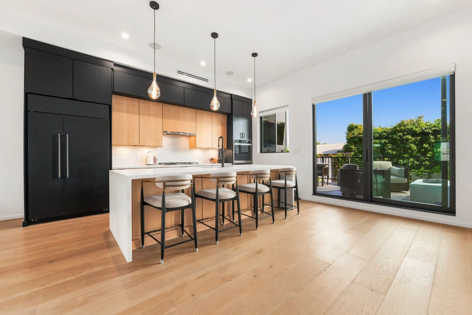 The kitchen opening toward the veranda through floor-to-ceiling glass