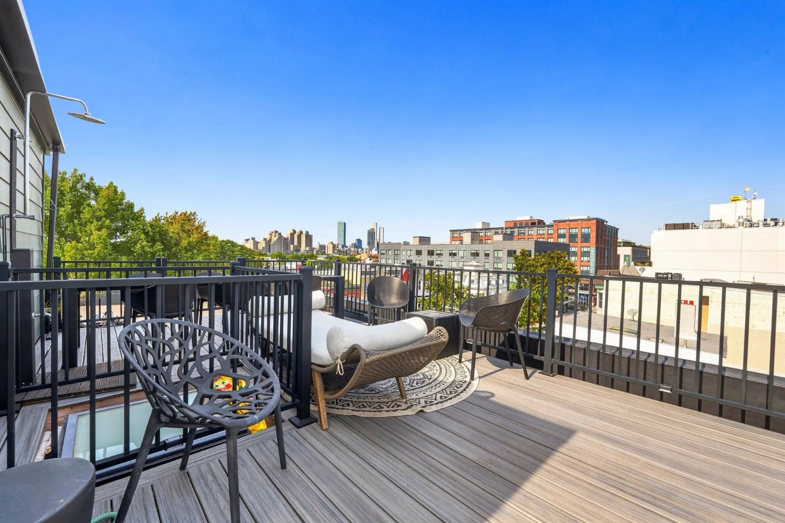 A rooftop corner with lounge chairs and the city skyline in the distance