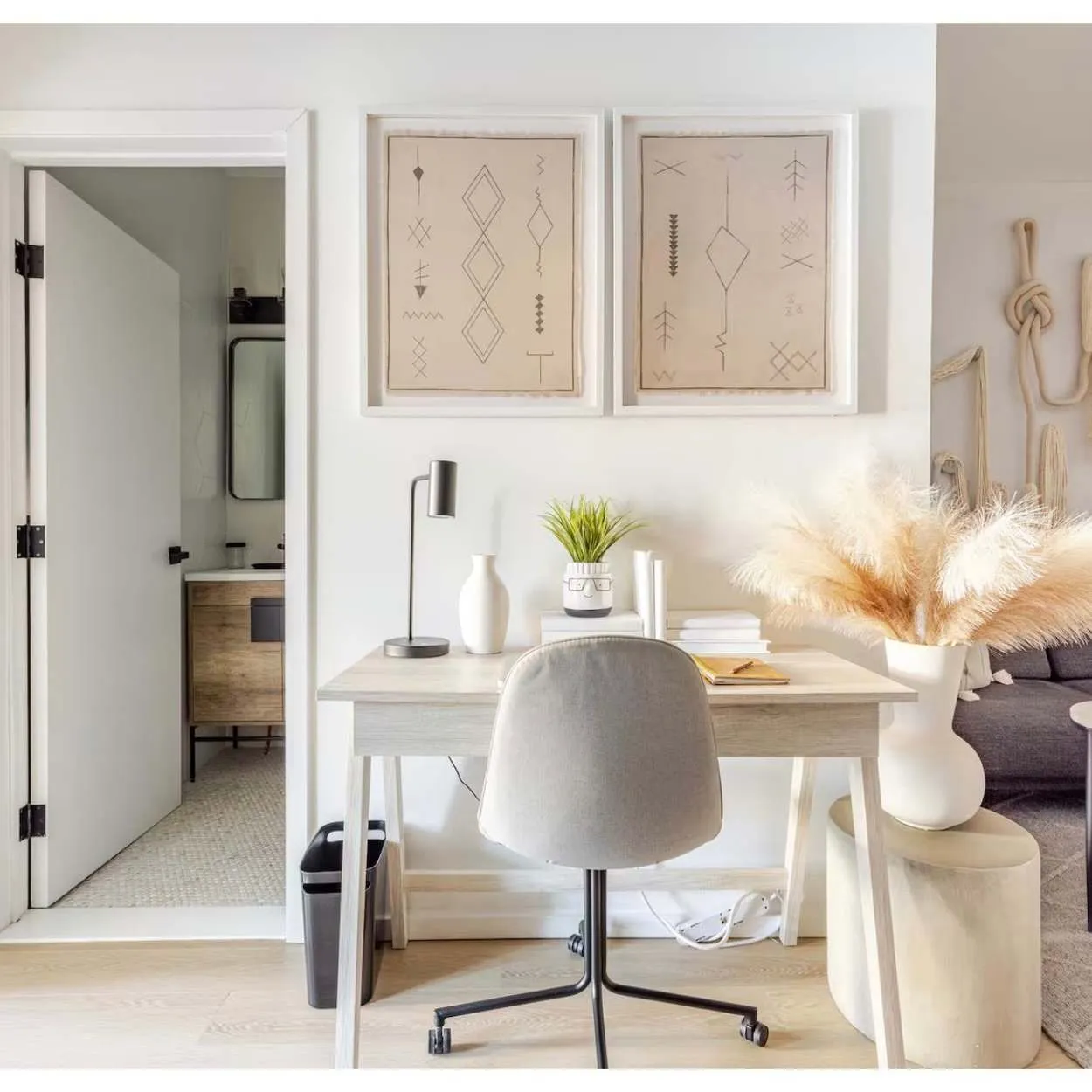 A compact workspace with a white desk and framed artwork